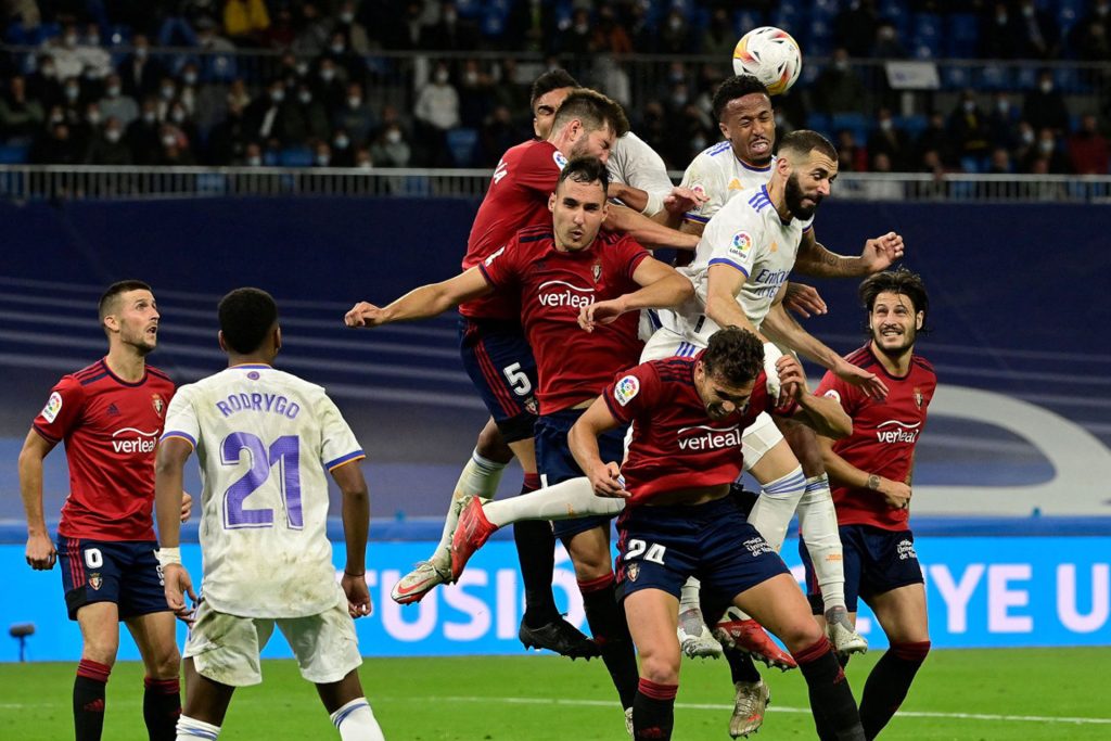 لاعبون يتقاتلون من أجل الكرة خلال مباراة كرة قدم بالدوري الإسباني بين "ريال مدريد" و"أوساسونا" في مدريد في 27 أكتوبر 2021